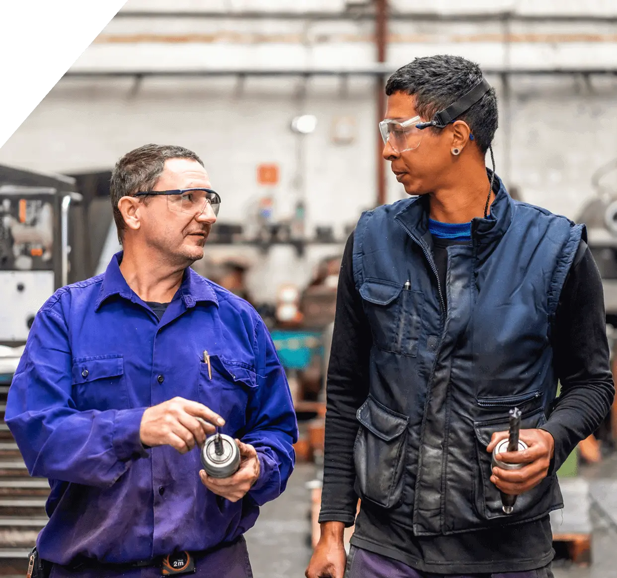 Two workers talking in a workshop.
